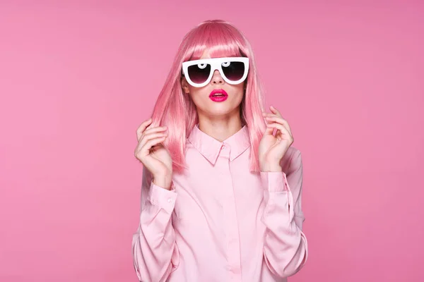 ピンクのウィッグを着た女性とピンクの背景のスタジオのサングラス — ストック写真