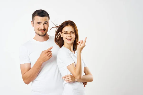 Young  couple  in studio pointing on isolated background