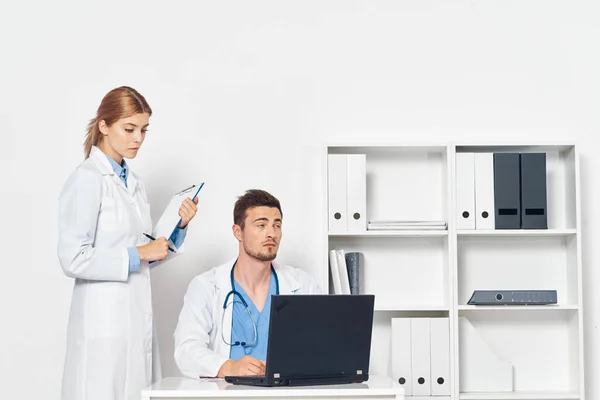 Young doctor with laptop  and nurse in hospital