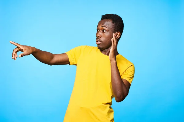 Genç Afrikalı Bir Adam Mavi Arka Planda Parmak Göstererek Izole — Stok fotoğraf