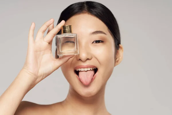 Portrait of  beautiful asian woman with  perfume  on isolated background