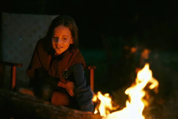 可爱的漂亮姑娘晚上坐在篝火边 — 图库照片
