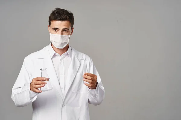 Studio shot. Young doctor in mask  on  isolated background