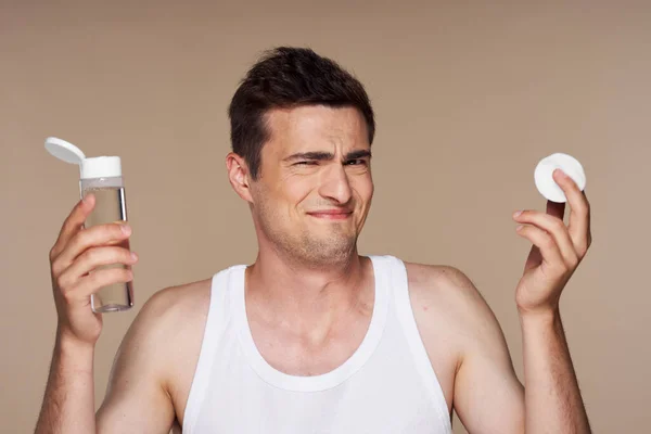 young handsome   confused  man  with lotion in bathroom