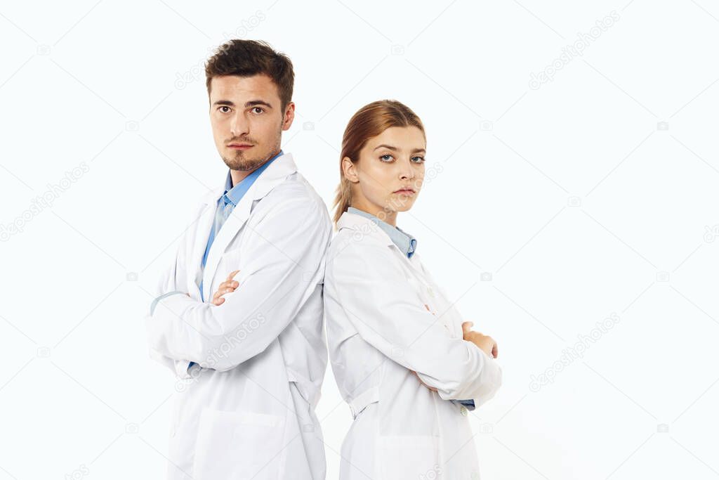 Young doctors standing in studio, isolated background. 