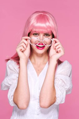 Stüdyo çekimi. Pembe peruk ve gözlüklü genç kız. 