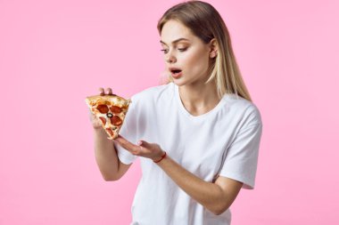İzole edilmiş arka planda pizza yiyen genç ve güzel bir kadın. 