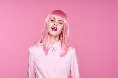 Pembe peruklu güzel bir kadının pembe arka planda poz verirken sudio çekimi.