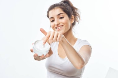   Genç ve güzel bir kadın izole edilmiş arka planda stüdyoya el kremi sürüyor.          