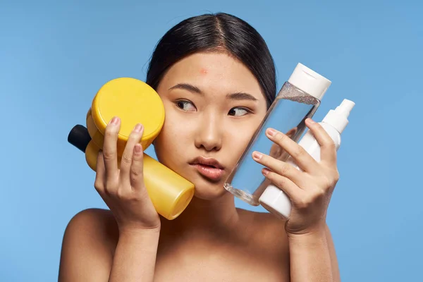 asian woman with beauty products   in studio on isolated background