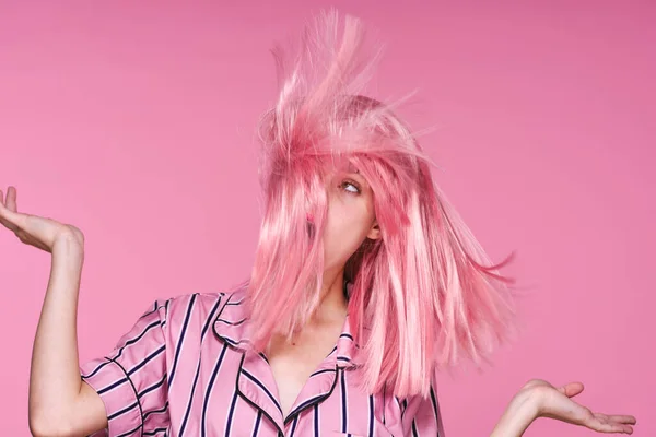 スタジオショットの美しいです女性でピンクウィッグ吹いて髪上のピンクの背景 — ストック写真
