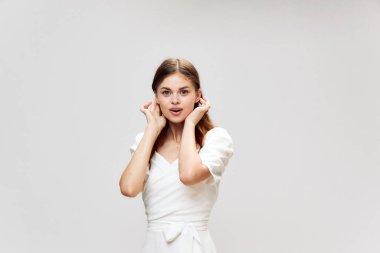 Kadın beyaz elbisesini düzeltiyor. Gülümsüyor. Önüne bak. 