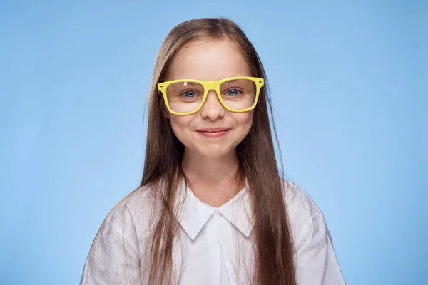 Vrolijk klein meisje in wit shirt bril Studio blauw achtergrond leuk jeugd — Stockfoto