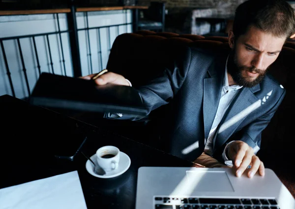 Homem de negócios sentado em um café na frente de um laptop com uma xícara de café estilo de vida tecnologia de trabalho — Fotografia de Stock