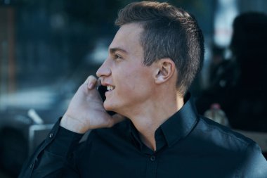 Kafe cep telefonu iletişim müdürü modelinde yakışıklı bir iş adamı.