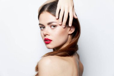 Çekici bir kadın. Temiz tenli, eli kafasında, kırmızı dudaklı, doğal görünüşlü.