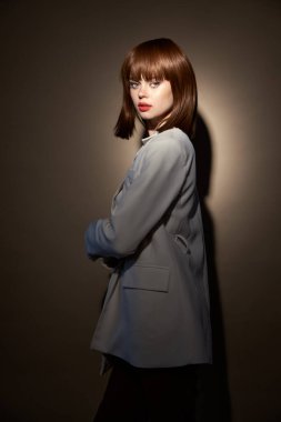 Moda kıyafetleri içinde esmer. Kamera bej arka planına bak.