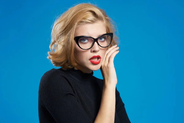 Blond med kort hår röda läppar glasögon svart jacka blå isolerad bakgrund — Stockfoto
