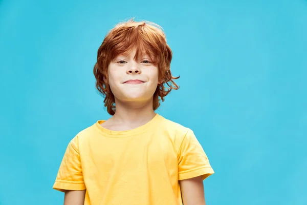 Uśmiechnięte dziecko z czerwonymi włosami na niebieskim tle koszulki. — Zdjęcie stockowe