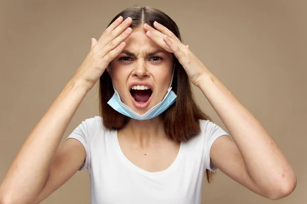 Femme surprise avec un masque médical sur le menton grande bouche ouverte et les mains — Photo