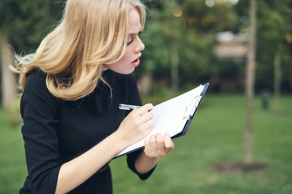 Vue recadrée de femme blonde avec des documents dans les mains dans la nature — Photo