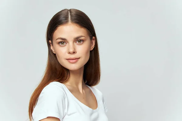 Mulher em branco T-shirt olha para a frente em fundo isolado Espaço Copiar — Fotografia de Stock