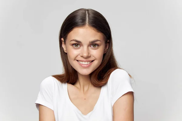 Mulher sorridente em camiseta branca olhando para a frente — Fotografia de Stock