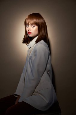 Moda kıyafetleri içindeki çekici kadın kameraya poz veriyor. 