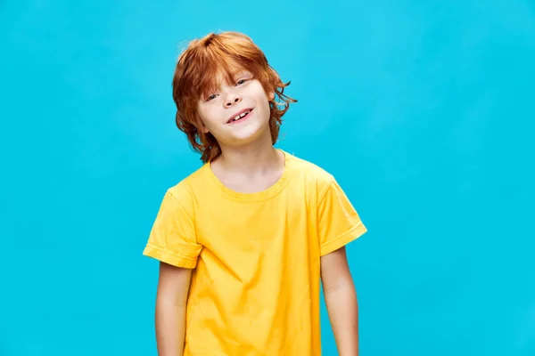 Glad pojke med rött hår leende och lutade huvudet — Stockfoto