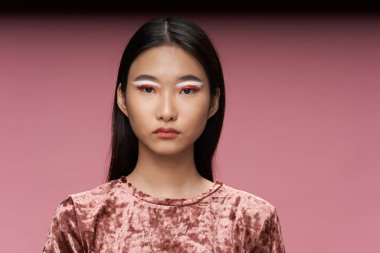 Parlak makyajlı, Asyalı görünümlü, lüks, temiz ciltli bir kadın. 