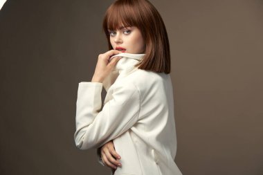 Moda kıyafetleri içindeki kendine güvenen kadın kameraya poz veriyor. 