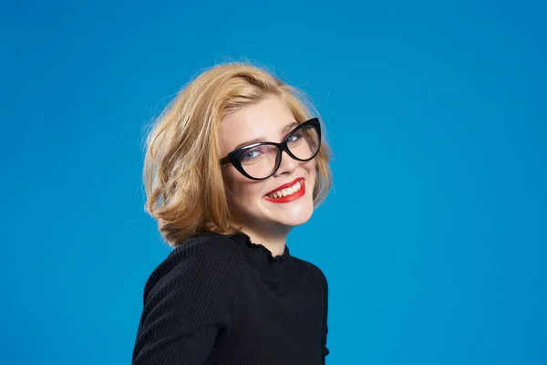Blond mit kurzen Haaren rote Lippen Brille schwarze Jacke blau isolierter Hintergrund — Stockfoto