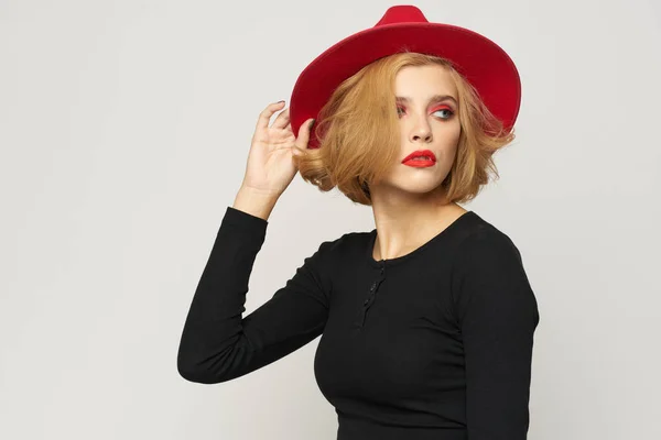 Fashionable woman in red hat black blouse red lips cropped view light background emotions — Stock Photo, Image