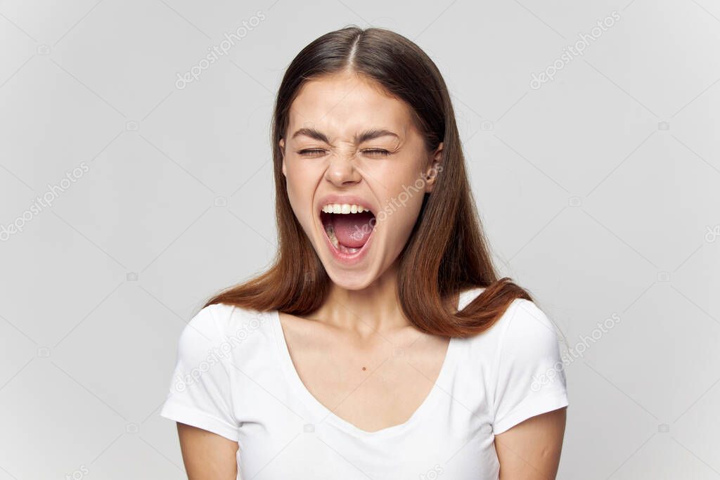 Emotional woman with closed eyes opened her mouth wide 