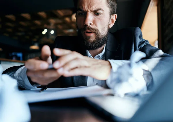 Uomo d'affari seduto a tavola davanti al computer portatile carta accartocciata stile di vita executive tecnologia del lavoro — Foto Stock
