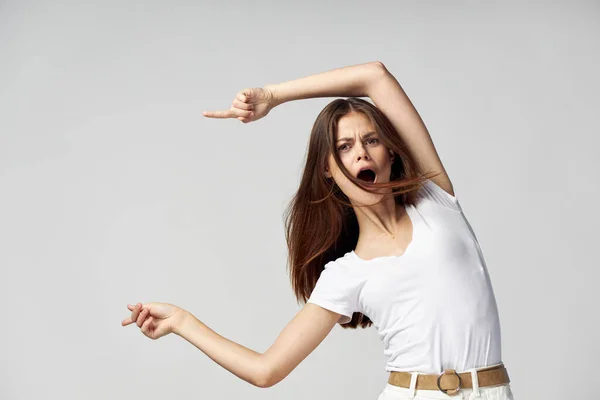 Kvinna med öppen mun visar fingrar på sidan känslor vit t-shirt — Stockfoto