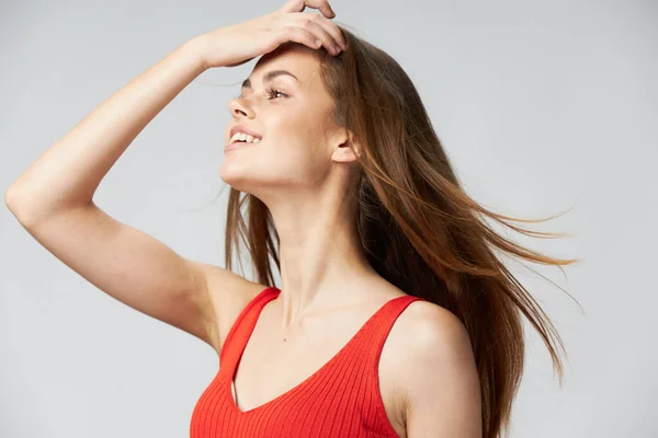 Mujer con el pelo largo está tocando su cabeza con la mano y la camiseta roja —  Fotos de Stock