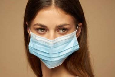 Sağlık koruma maskesi takmış bir kadının portresi. 