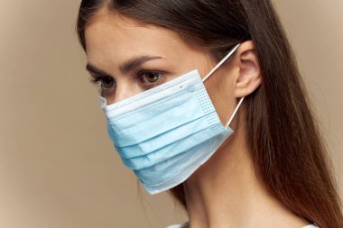 Kadın koruyucu tıbbi maske portresi. Yakın plan kırpılmış görüntü.