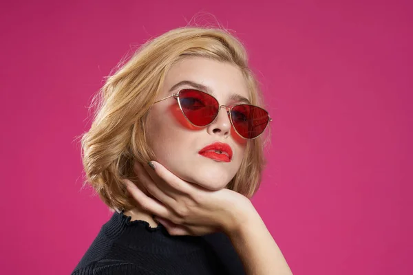 Vacker kvinna i mörka glasögon ljus makeup svart jacka närbild rosa bakgrund — Stockfoto
