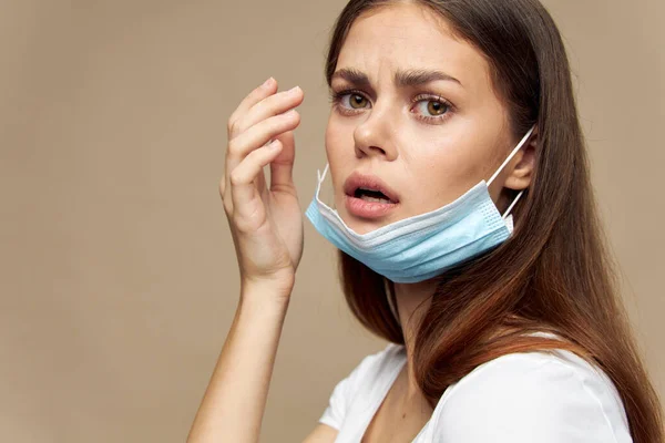 Hermosa mujer con una máscara médica en su cara una mirada asustada emociones — Foto de Stock