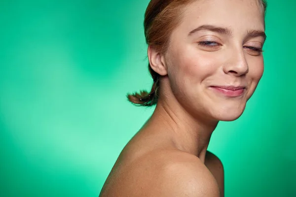 Woman with clean skin face procedures cosmetology naked shoulders green background