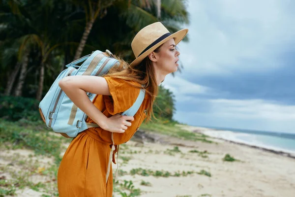 Woman tourist with heavy backpack travel to island landscape