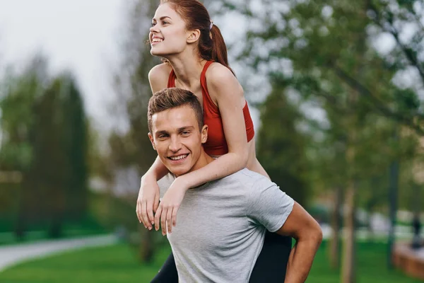 Woman on back men outdoors walk fun lifestyle — Stock Photo, Image