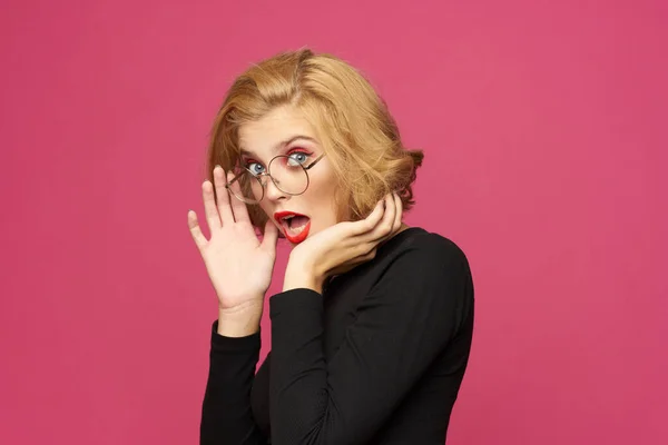 Hübsche Frau im schwarzen Pullover kurze Frisur Brille rosa isolierten Hintergrund — Stockfoto