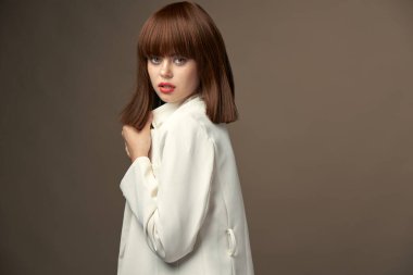 Elleriyle jestler yapan bej ceketli şık bir manken. 