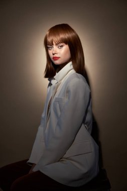 Moda kıyafetleri içinde şık bir model kameraya poz veriyor.