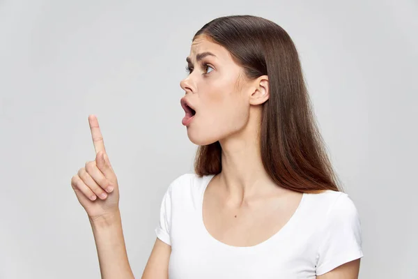 Девушка в белой футболке на изолированном фоне открыла рот и показала большой палец — стоковое фото