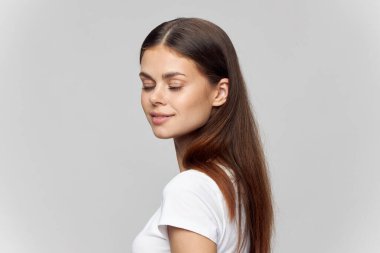 Esmer, açık renk tişörtlü, arka planda izole bir gülüşü olan. 