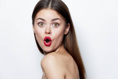 Şaşkın bakışlı, kırmızı dudaklı, çıplak omuzlu, açık tenli hoş bir kadın. 